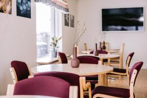 une salle à manger avec des tables et des chaises violettes dans l'établissement Eldá Guesthouse, à Mývatn