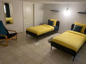 una habitación de hotel con 2 camas y una silla en Le cocon d'Emma en Sélestat