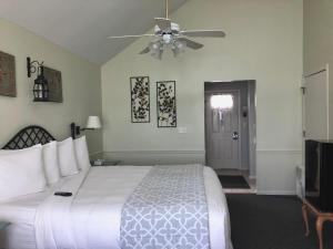 a bedroom with a white bed and a ceiling fan at The French Country Inn in Lake Geneva