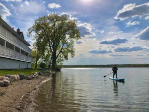 a man on a paddle board in the water at The French Country Inn in Lake Geneva
