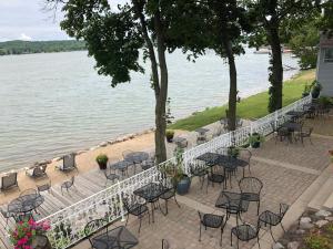 a row of tables and chairs next to the water at The French Country Inn in Lake Geneva