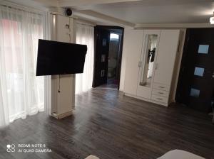 uma sala de estar com uma televisão de ecrã plano na parede em Casa Vladimirescu em Drobeta-Turnu Severin