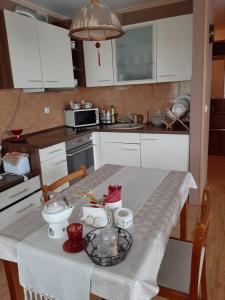 une cuisine avec une table et un chiffon de table blanc dans l'établissement Neravu namai, à Druskininkai