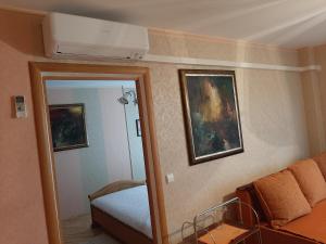 Cette chambre comprend un lit, un canapé et un miroir. dans l'établissement Neravu namai, à Druskininkai
