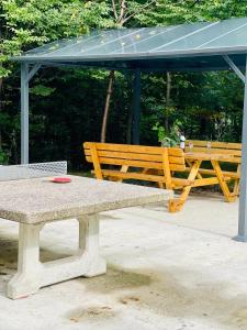 a picnic table and a bench in a park at PREMIUM-Ferienhaus für 5 Gäste - Sauna, Wald u. Berge Extertal-Ferienpark #49 in Extertal