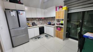 a kitchen with white cabinets and a stainless steel refrigerator at 樂南居 in Tainan
