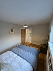 a bedroom with a bed with a blue bedspread at Sandscroft Annex 5A in Broadway