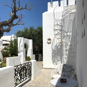 eine Wendeltreppe aus Metall an der Seite eines weißen Gebäudes in der Unterkunft Bungalows Svoronos in Naoussa