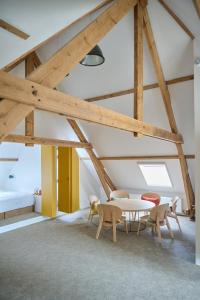 um quarto com uma mesa e cadeiras e uma cama em La Compagnie des Moëres em Veurne