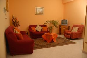 a living room with two red chairs and a table at GB Case Vacanze Sicilia in Balestrate