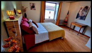 a bedroom with a bed and a desk and a window at Les Jardins de Kuz - Lion in Bernin