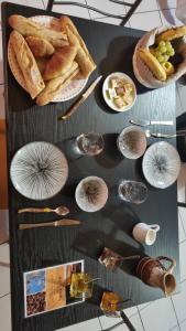 a table topped with plates of food and wine glasses at Lion-Les Jardins de Kuz in Bernin