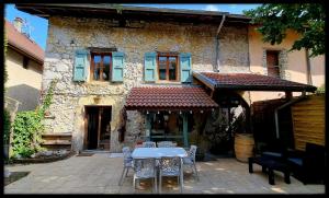 a table and chairs in front of a building at Lion-Les Jardins de Kuz in Bernin