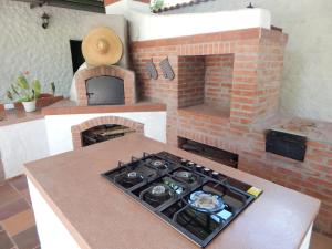 a kitchen with a stove and a brick oven at B&B Villa CALASAN in Garzón