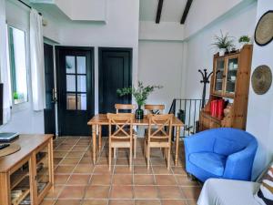 ein Wohnzimmer mit einem Holztisch und einem blauen Stuhl in der Unterkunft CASA EL SUEÑO DE ARACENA in Aracena