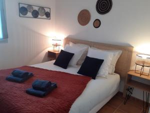 a bedroom with a bed with two blue pillows on it at Le Pietra in Uzès