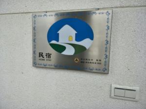 a sign for a building with a door on a wall at 晨民宿 Morning Homestay in Puli