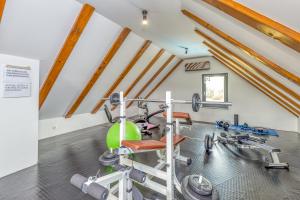 a room with a gym with a bench and weights at Mali raj in Oštarije