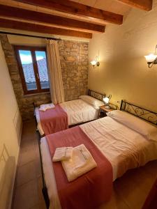 a bedroom with three beds and a window at Complejo Rural La Glorieta in Catí