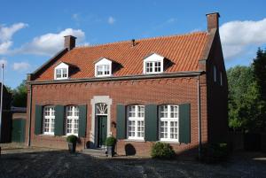 una casa de ladrillo rojo con techo rojo en Vakantiehuis De Vorster Pastorie, en Broekhuizenvorst