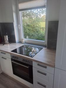 a kitchen with a window and a stove top oven at FerienhausWeseby in Hürup