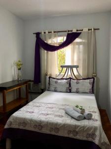 um quarto com uma cama com duas almofadas e uma janela em Casa com piscina em Aldeia Velha em Quartéis