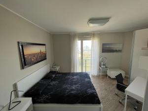 a bedroom with a bed and a desk and a window at SKYLINE MILANO Fiera in Milan