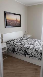 ein Schlafzimmer mit einem schwarzen und weißen Bett mit einem Bild an der Wand in der Unterkunft SKYLINE MILANO Fiera in Mailand