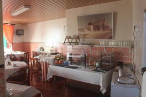 um restaurante com mesas e toalhas de mesa brancas em Residencial Miguel José em Estremoz