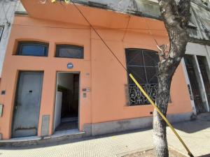 un bâtiment orange avec un arbre devant lui dans l'établissement Medio Mundo, à Buenos Aires