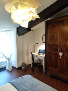 1 dormitorio con cama, escritorio y lámpara de araña en Chateau Ysard, en Camblanes-et-Meynac