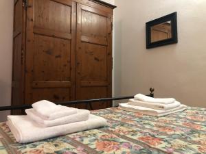 uma pilha de toalhas sentadas em cima de uma cama em Residenza Porta all'Arco em Volterra