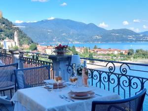 a table on a balcony with a view of the water at Hotel La Rondinella in Cannero Riviera