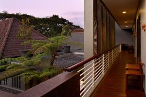 Un balcón de una casa con plantas. en COZY Boutique Guest House en Malang