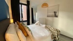 een slaapkamer met een bed met witte lakens en kussens bij Oneluxstay Antwerp City Centre in Antwerpen