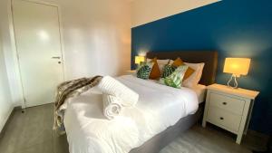 sypialnia z dużym białym łóżkiem z niebieską ścianą w obiekcie Oneluxstay Antwerp City Centre w Antwerpii