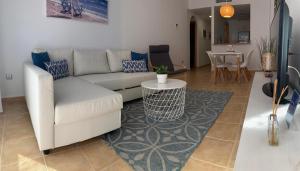 sala de estar con sofá blanco y mesa en Las Brisas Mojacar Home, en Mojácar