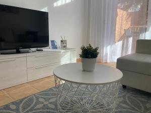 a living room with a white table and a tv at Las Brisas Mojacar Home in Mojácar