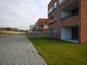 ein Backsteingebäude mit einem Rasenplatz davor in der Unterkunft Oostendenachten in Ostende