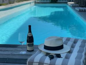 a hat and a glass of wine next to a swimming pool at Sea Five Boutique Hotel in Cape Town