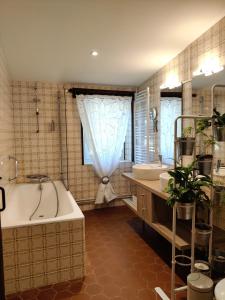 y baño con bañera, 2 lavabos y bañera. en Chateau Ysard, en Camblanes-et-Meynac