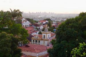 Vistas a una ciudad con un edificio y árboles en Estúdio dos sonhos com bela vista próximo ao alto da sé, en Olinda