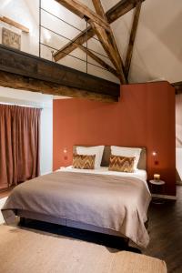 a bedroom with a large bed with an orange wall at B&B l'histoire de l'éclair in Bruges