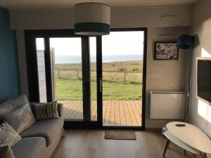 a living room with a couch and a large window at charmant studio vue mer in Wimereux