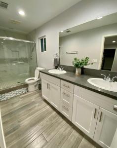 een badkamer met 2 wastafels, een douche en een toilet bij Cheers Hostel in Los Angeles