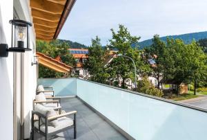 balcón con sillas y vistas a la calle en Schmuckstück Ferienapartments Bodenmais, en Bodenmais