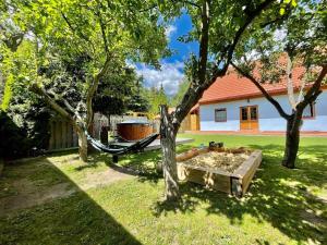 eine Hängematte in einem Hof neben zwei Bäumen in der Unterkunft KAPINA sk - Holiday Homes in Liptovská Sielnica