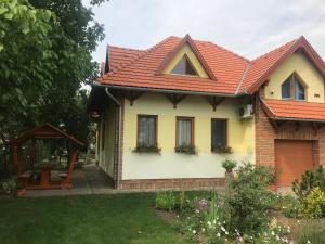 ein gelbes Haus mit rotem Dach in der Unterkunft Napfény apartman in Orosháza