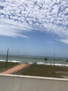 a view of a beach with a fence and the ocean at Pousada Souza & Souza in Barra Velha