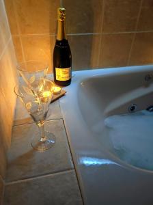 a bottle of wine and a wine glass next to a bath tub at La Casa de las Nereidas in Cuenca